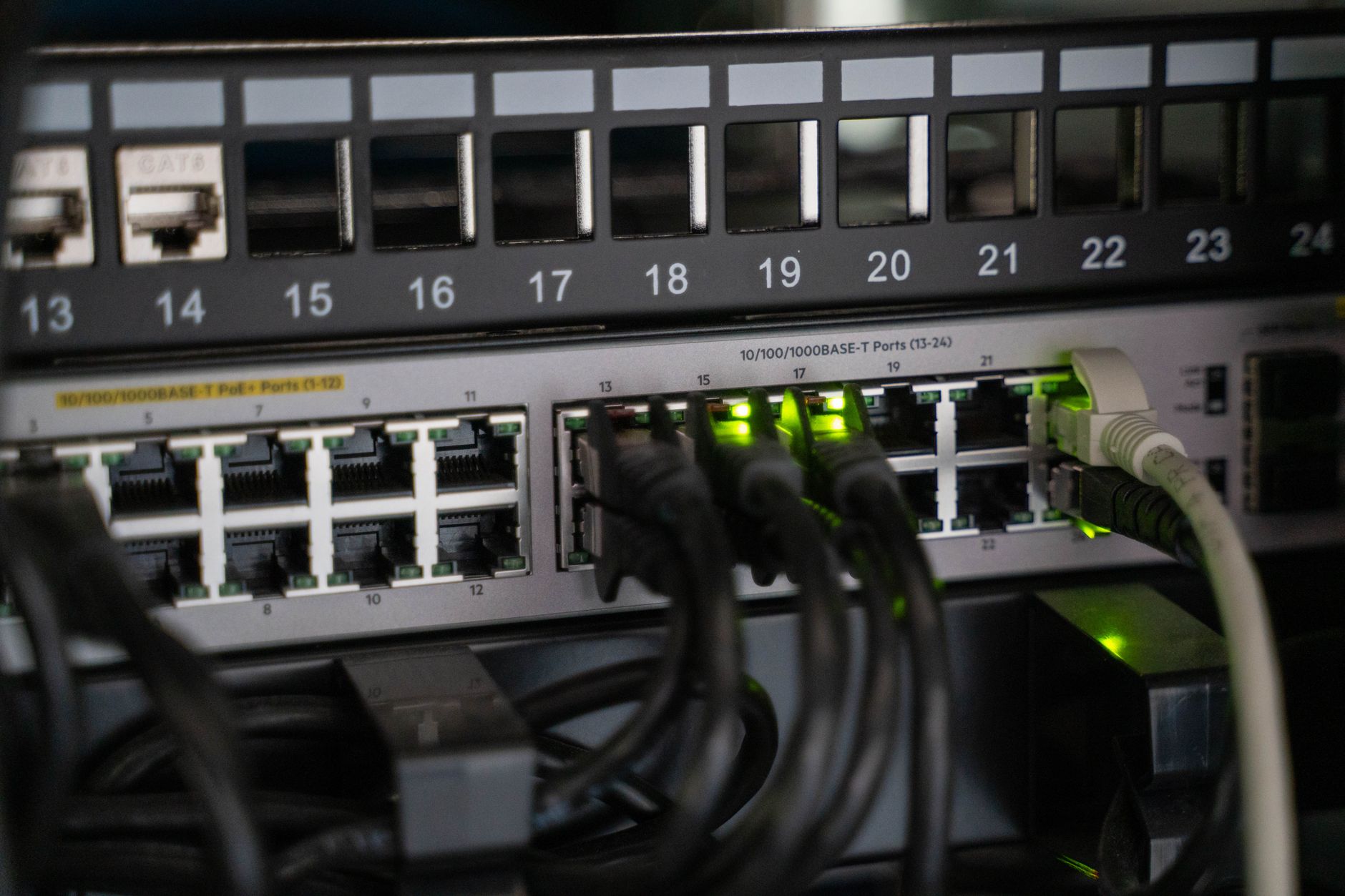 Switch réseau 24 ports PoE+ avec câbles RJ45 connectés et voyants verts allumés